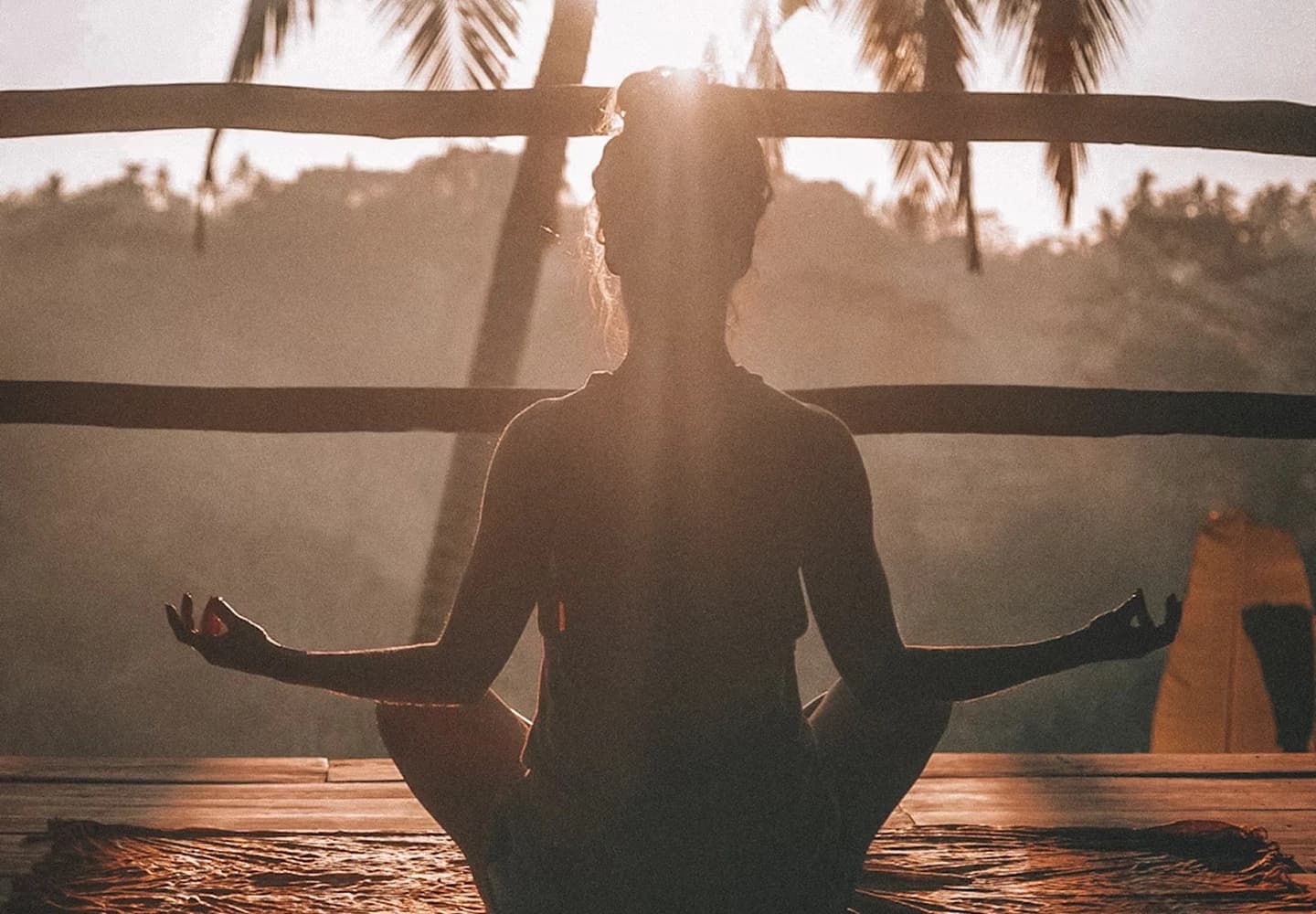A woman meditating the sun